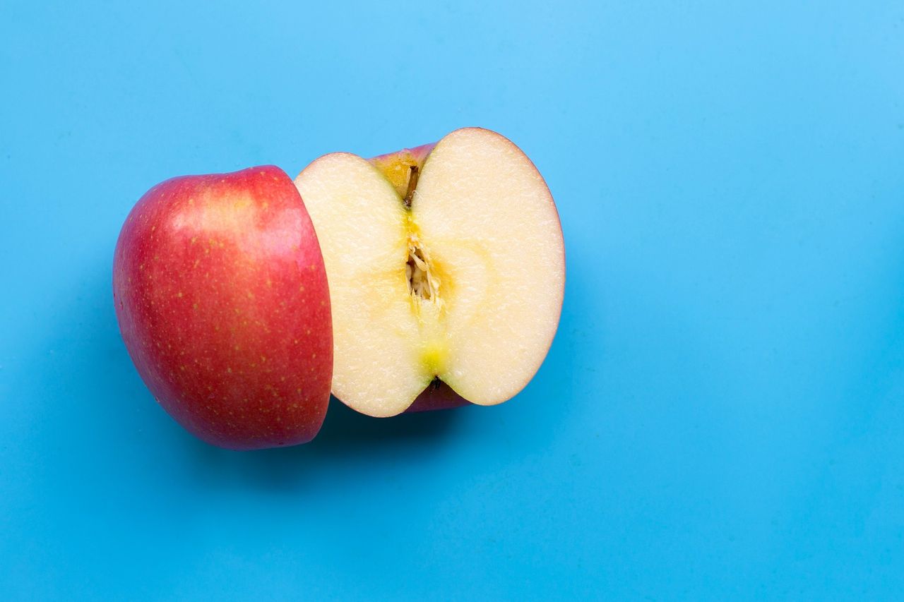 Яблоко, разрезанное на две части, дольки