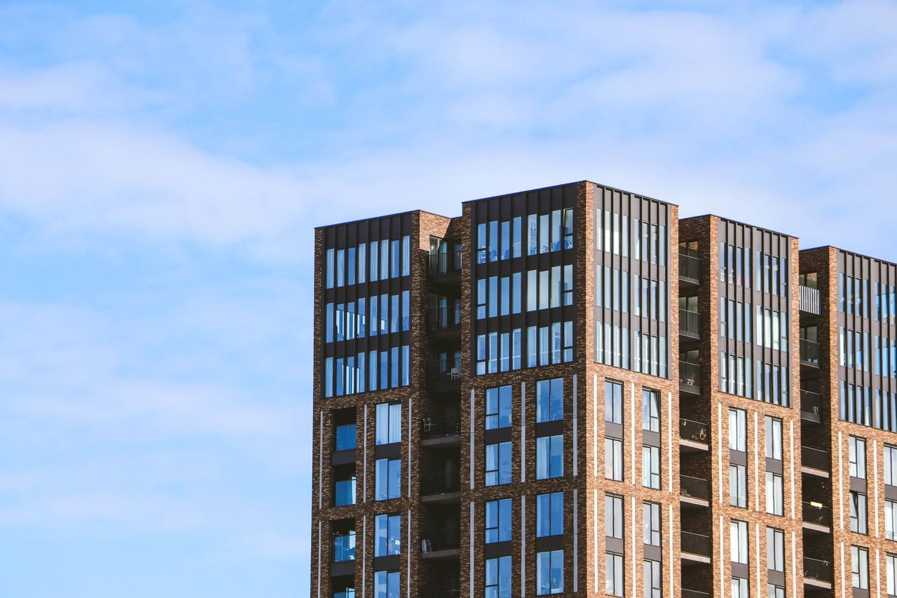 новостройка кирпичный фасад, небо. Даже в новостройке купить квартиру по переуступке с использованием СИ, к сожалению, нельзя